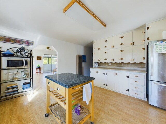 kitchen with stainless steel appliances, white cabinets, light wood-type flooring, and ceiling fan