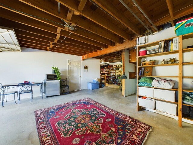 basement featuring stainless steel refrigerator