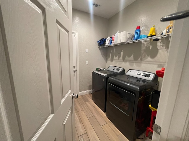 laundry room featuring washing machine and dryer and wood-type flooring