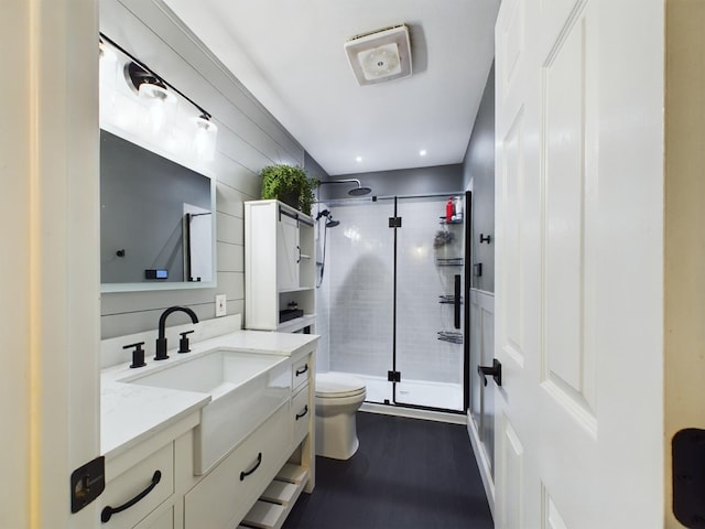 bathroom featuring vanity, toilet, and a shower with door