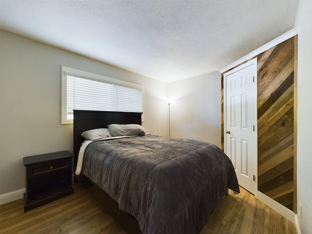 bedroom featuring a textured ceiling and dark hardwood / wood-style floors