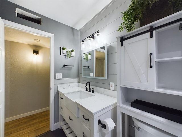 bathroom featuring wood-type flooring, vanity, and toilet