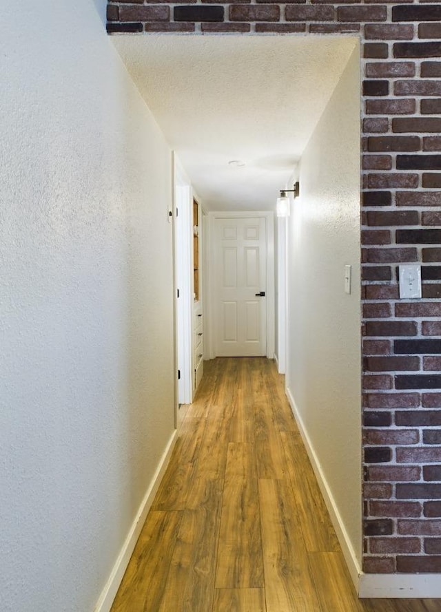 corridor featuring wood-type flooring and a textured ceiling