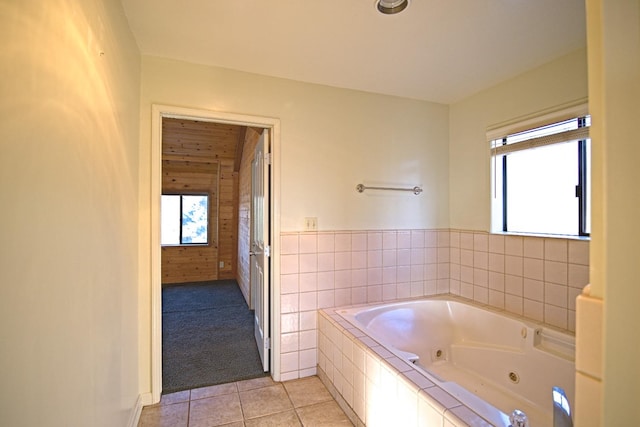 bathroom featuring a relaxing tiled tub and tile patterned flooring