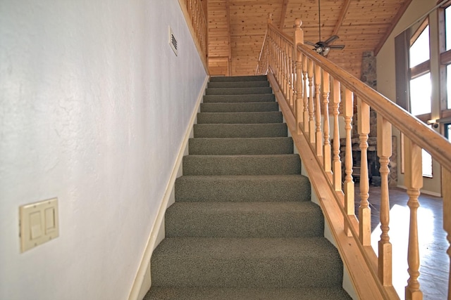 stairway with ceiling fan, wooden ceiling, wooden walls, high vaulted ceiling, and hardwood / wood-style flooring