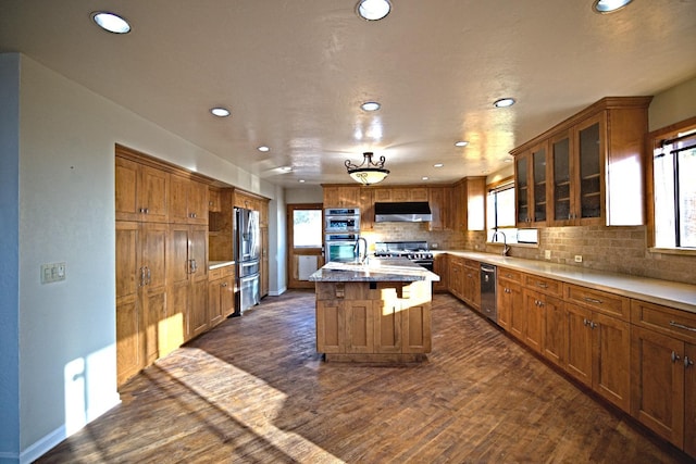 46149 Todd Eymann Rd, Miramonte, CA 93641 - kitchen with recessed lighting, under cabinet range hood, dark wood-type flooring, brown cabinets, and stainless steel appliances