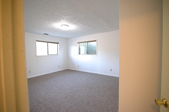 empty room with a textured ceiling and carpet