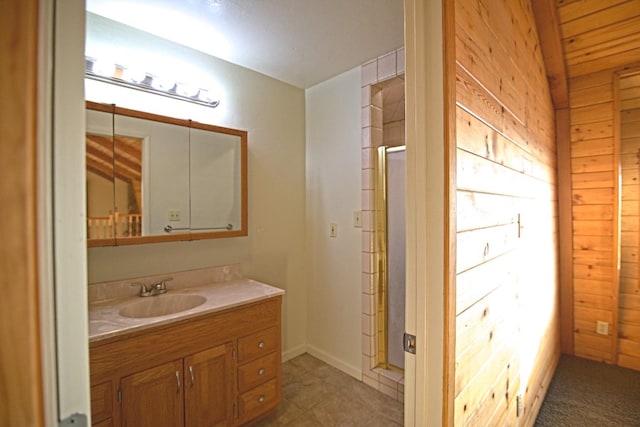 bathroom featuring a shower with door, wood walls, and vanity