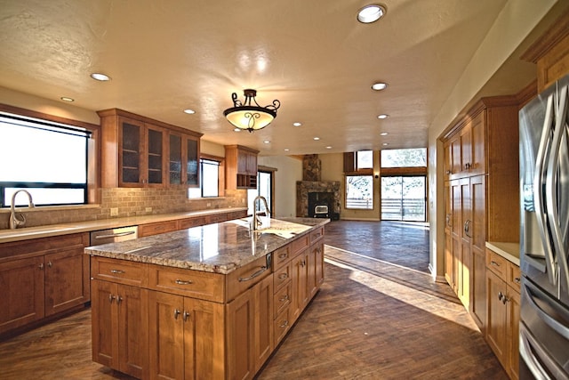 kitchen with an island with sink, plenty of natural light, dark wood-type flooring, and sink