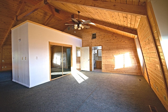 carpeted empty room featuring ceiling fan, beamed ceiling, wood ceiling, wood walls, and high vaulted ceiling