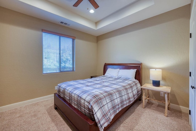 bedroom featuring a tray ceiling, carpet flooring, and ceiling fan