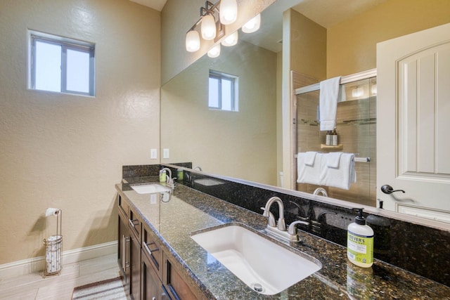 bathroom featuring hardwood / wood-style flooring, a wealth of natural light, walk in shower, and vanity