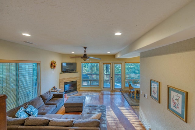 living room with ceiling fan, vaulted ceiling, and a textured ceiling