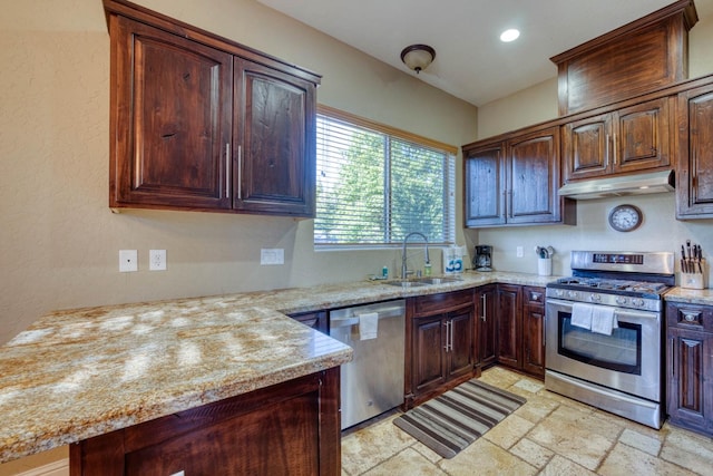 kitchen with light stone counters, dark brown cabinets, stainless steel appliances, and sink