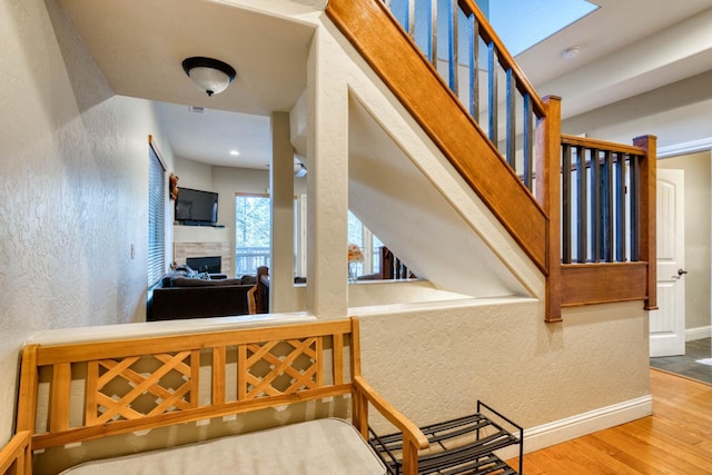 staircase featuring wood-type flooring and a skylight