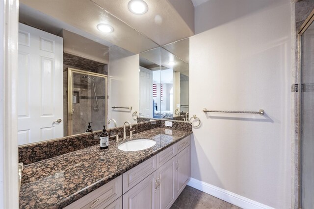 bathroom with tile patterned flooring, vanity, and a shower with shower door