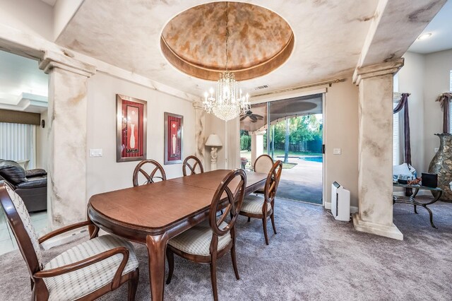 dining space featuring carpet floors, decorative columns, a chandelier, and a tray ceiling