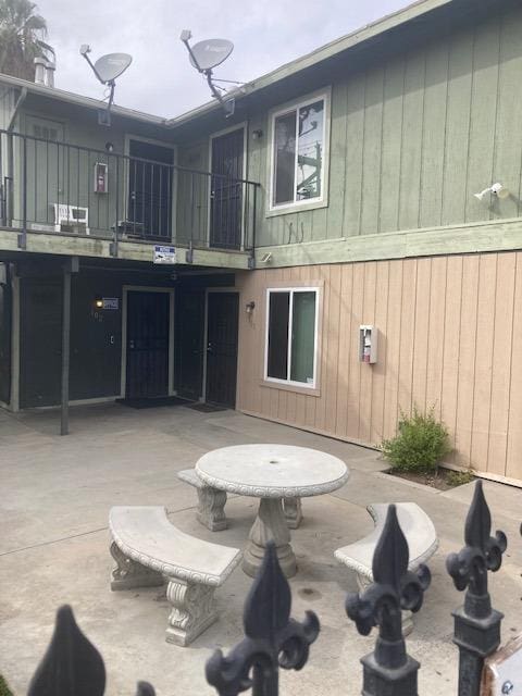 rear view of property featuring a patio and a balcony