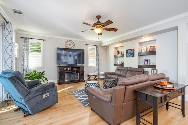 living room featuring ornamental molding, light hardwood / wood-style flooring, and ceiling fan