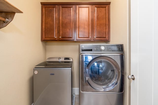 laundry room featuring cabinets and washing machine and clothes dryer