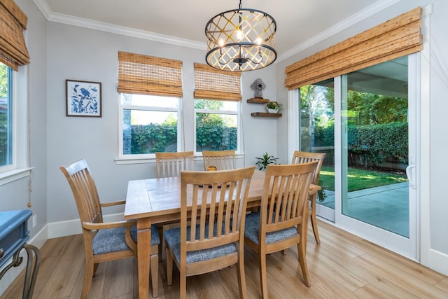 dining space featuring light hardwood / wood-style flooring, a chandelier, and crown molding