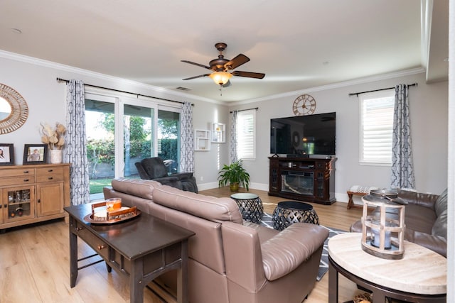 living room featuring ornamental molding, light hardwood / wood-style flooring, and ceiling fan