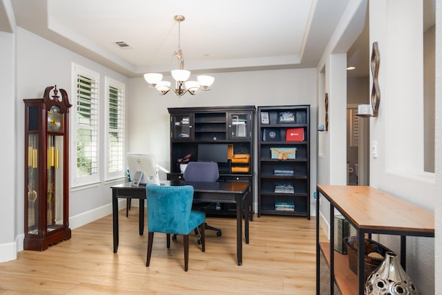 office area featuring hardwood / wood-style flooring, a chandelier, and a raised ceiling