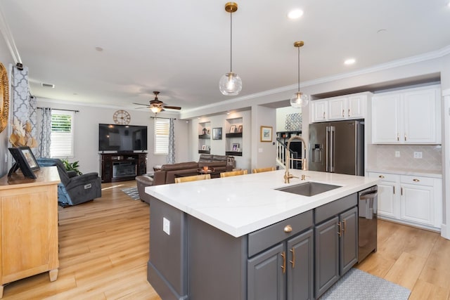 kitchen with appliances with stainless steel finishes, white cabinetry, light hardwood / wood-style flooring, pendant lighting, and gray cabinets