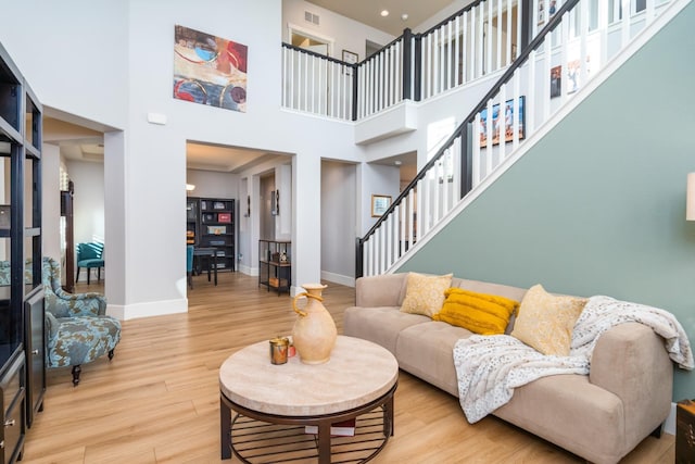 living room with wood-type flooring and a high ceiling