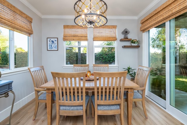 dining space featuring an inviting chandelier, ornamental molding, a healthy amount of sunlight, and light wood-type flooring