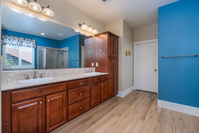 bathroom with vanity, wood-type flooring, and a shower with door