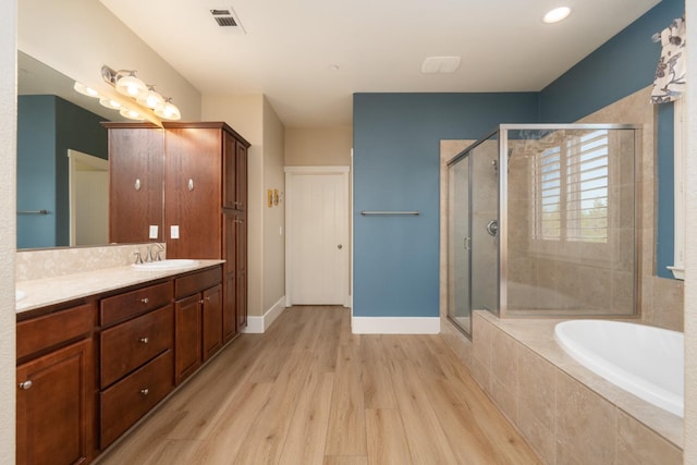 bathroom featuring vanity, shower with separate bathtub, and wood-type flooring