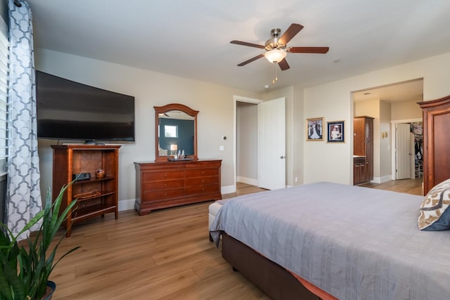 bedroom featuring light hardwood / wood-style floors, a closet, connected bathroom, and ceiling fan