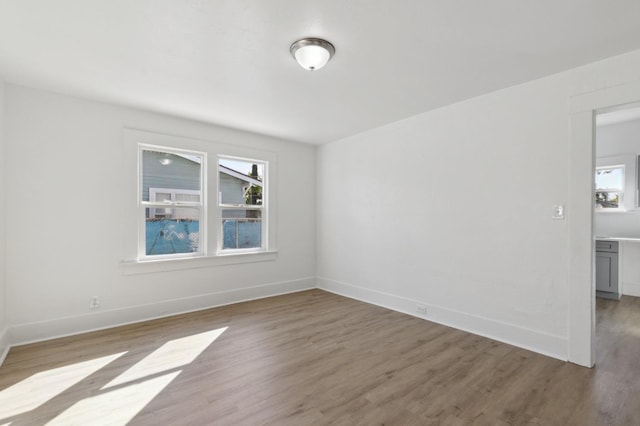 unfurnished room featuring baseboards, a healthy amount of sunlight, and light wood-type flooring