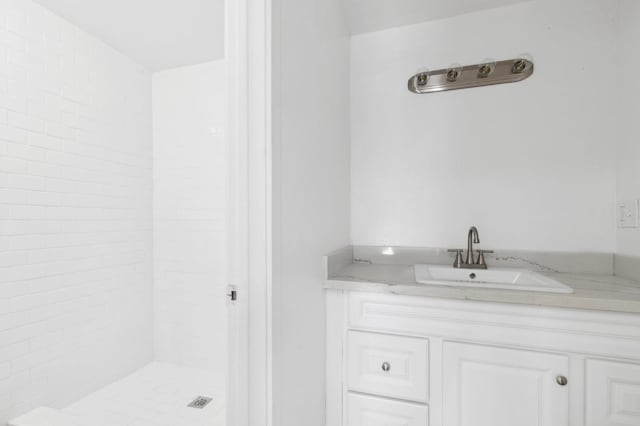 bathroom with vanity and a tile shower