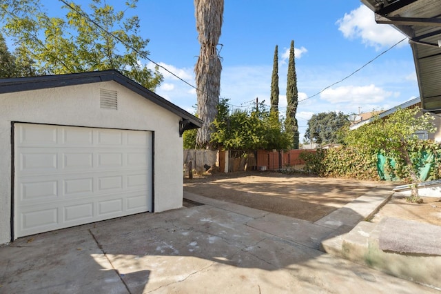 detached garage with driveway and fence