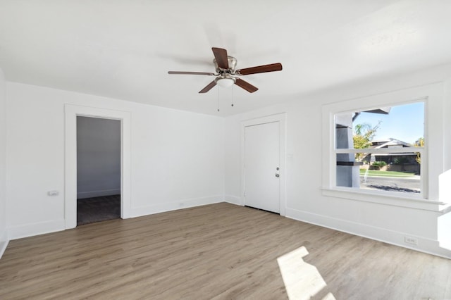 unfurnished room featuring wood finished floors, baseboards, and ceiling fan