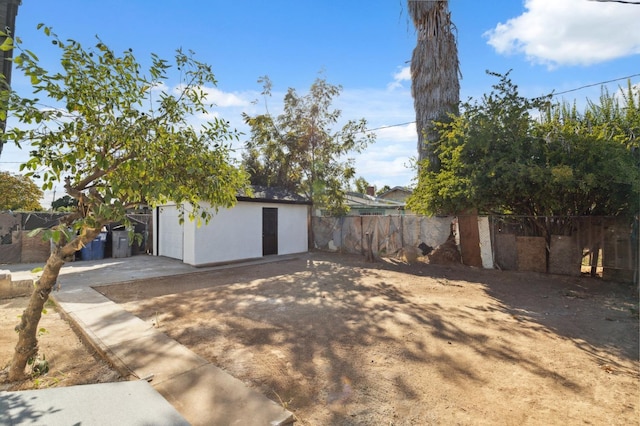 view of yard featuring fence and an outbuilding