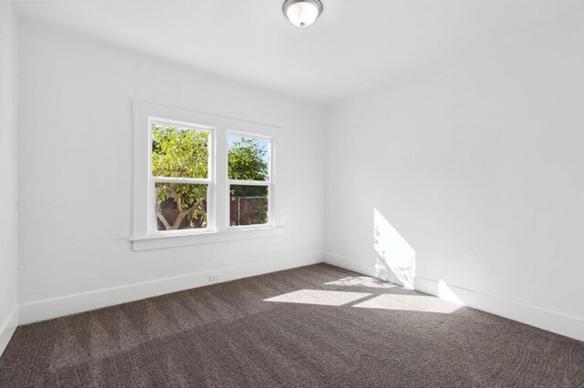 spare room featuring carpet floors and baseboards