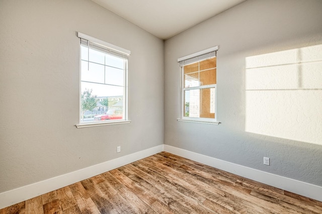 unfurnished room with baseboards and wood finished floors