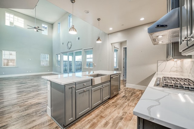 kitchen featuring a sink, gray cabinets, range hood, a ceiling fan, and stainless steel dishwasher