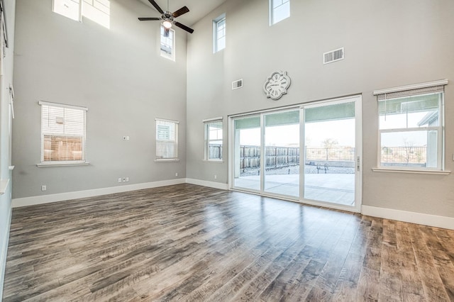 interior space featuring ceiling fan, plenty of natural light, visible vents, and wood finished floors