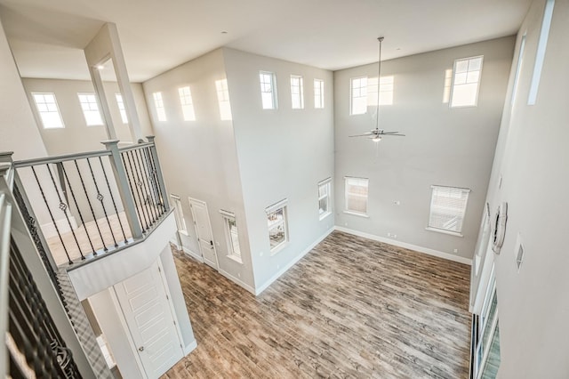 interior space featuring ceiling fan, baseboards, and wood finished floors