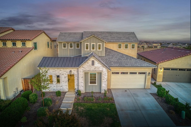 view of front of house featuring an attached garage, metal roof, concrete driveway, board and batten siding, and a standing seam roof