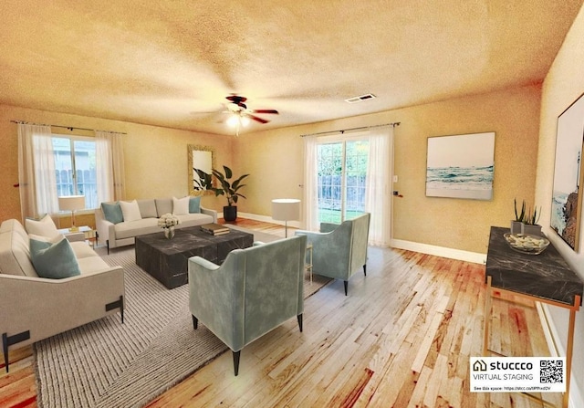 living room featuring ceiling fan, light hardwood / wood-style flooring, and a textured ceiling