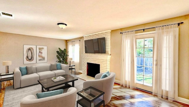 living room featuring a brick fireplace and light wood-type flooring