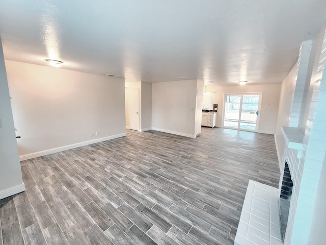 unfurnished living room with a fireplace and hardwood / wood-style floors