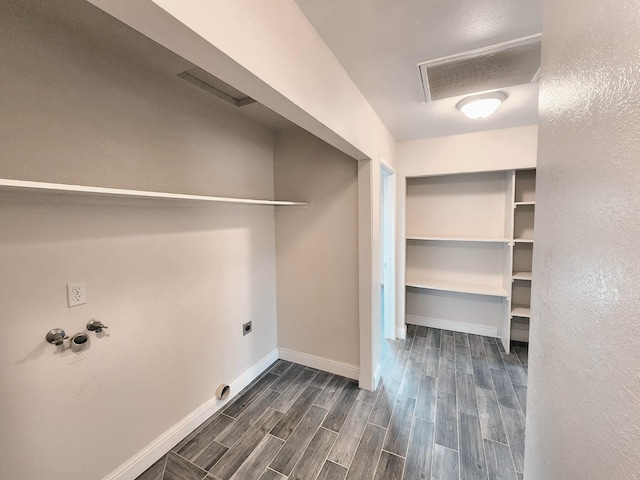 clothes washing area featuring electric dryer hookup and dark hardwood / wood-style flooring