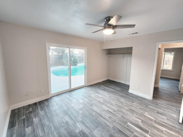 unfurnished bedroom featuring a closet, access to exterior, light wood-type flooring, and ceiling fan