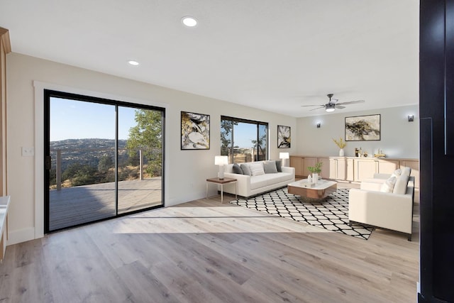 unfurnished living room with ceiling fan, a healthy amount of sunlight, and light hardwood / wood-style flooring